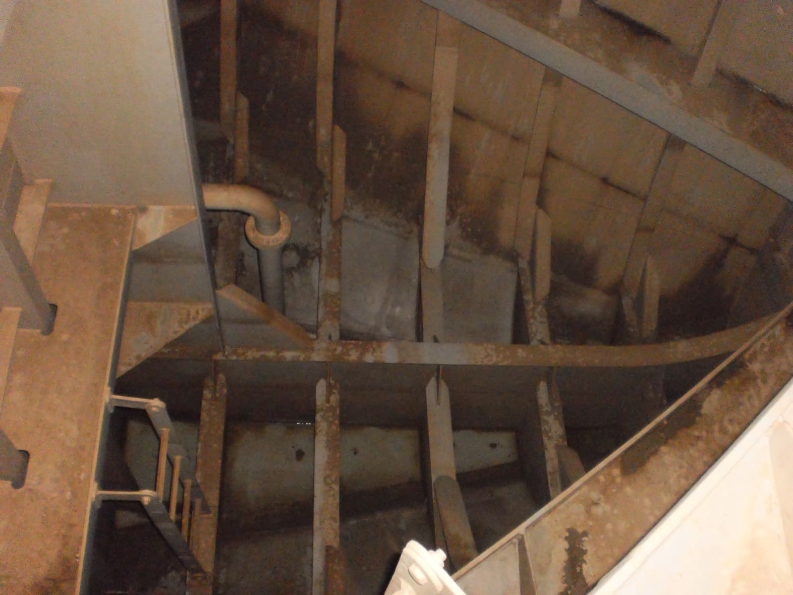 Inside a ship’s forepeak ballast tank: the ladder down, frames and stiffeners, and a pipe running to the bottom.